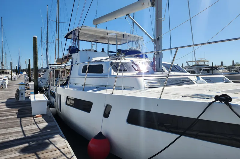 Slide: The Image of 2021 Royal Cape Catamarans Majestic 570 docked at marina under clear blue sky. - 2