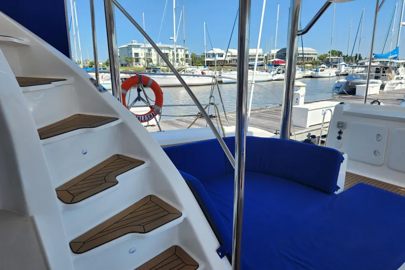 Slide: The Image of Luxurious Royal Cape Catamarans Majestic 570 yacht interior with blue seating and marina view. - 23