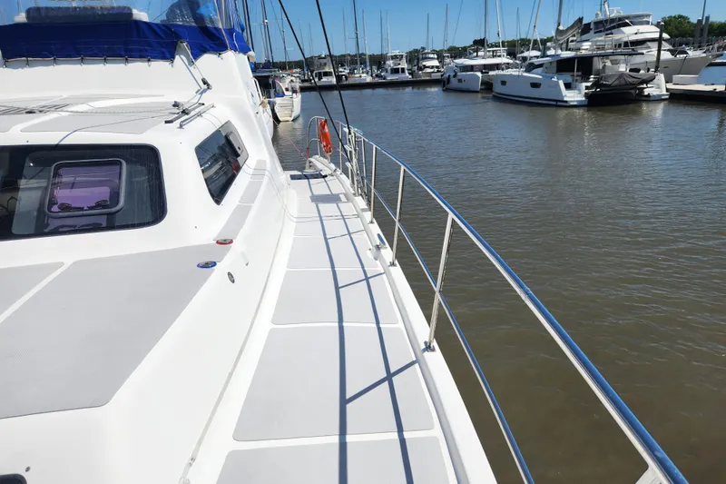 Slide: The Image of 2021 Royal Cape Catamarans Majestic 570 docked at marina, showcasing sleek deck design. - 29