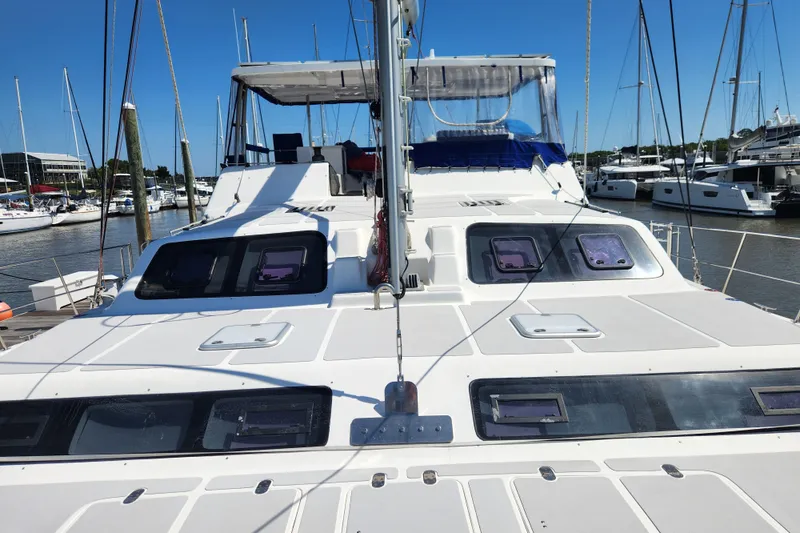 Slide: The Image of 2021 Royal Cape Catamarans Majestic 570 docked at a marina, showcasing sleek design and spacious deck. - 34