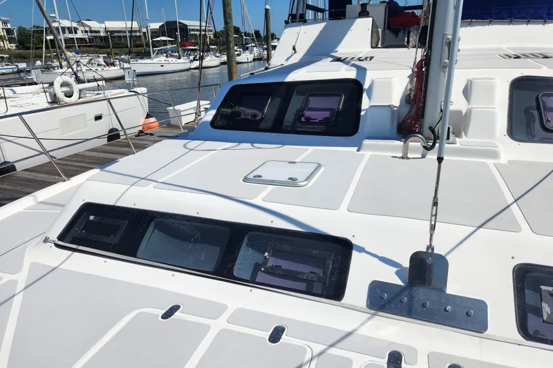 Slide: The Image of 2021 Royal Cape Catamarans Majestic 570 docked at a marina, showcasing sleek design and windows. - 36