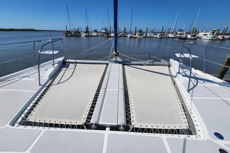 Slide: The Image of 2021 Royal Cape Catamarans Majestic 570 catamaran deck with netting, docked at marina. - 44