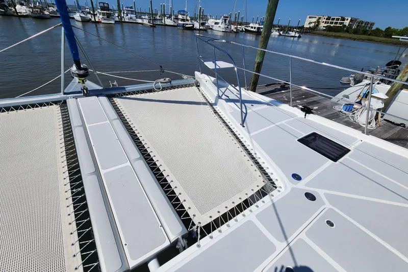 Slide: The Image of 2021 Royal Cape Catamarans Majestic 570 catamaran docked at a marina, showcasing deck and netting. - 45