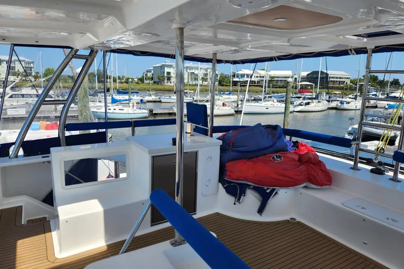 Slide: The Image of Interior view of 2021 Royal Cape Catamarans Majestic 570 at marina, featuring seating and storage. - 54