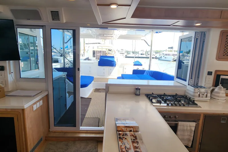 Slide: The Image of Interior view of 2021 Royal Cape Catamarans Majestic 570, featuring modern kitchen and outdoor seating. - 60