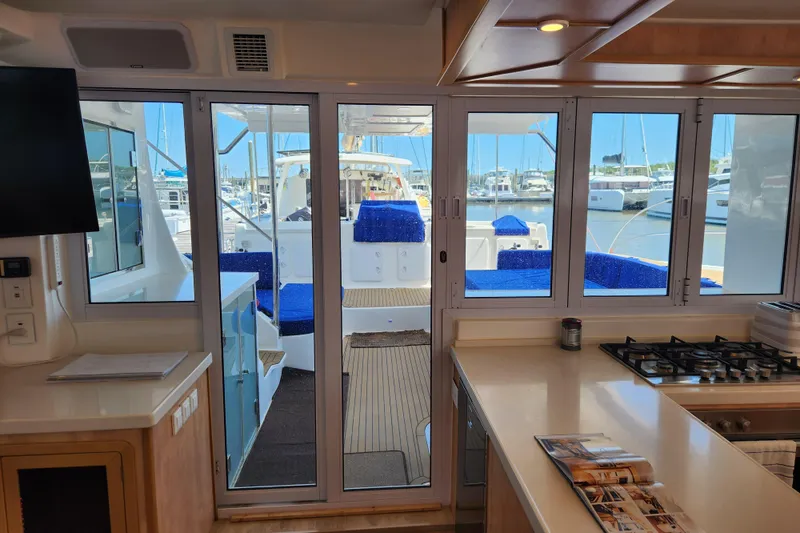 Slide: The Image of Interior view of 2021 Royal Cape Catamarans Majestic 570, showcasing kitchen and marina through windows. - 61