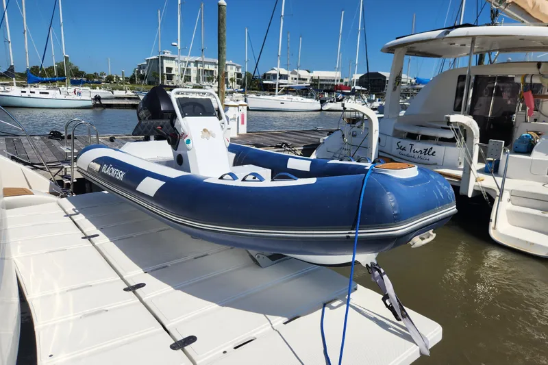 Slide: The Image of Blue inflatable boat on a Royal Cape Catamarans Majestic 570, docked at a marina. - 7
