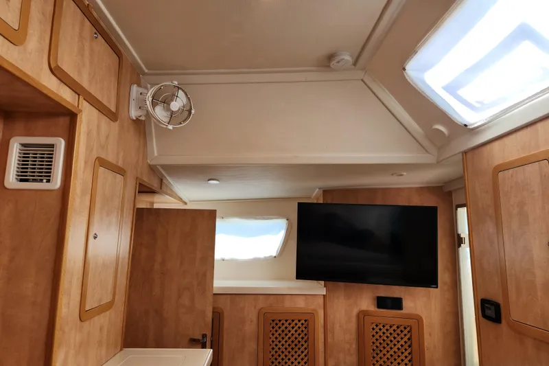 Slide: The Image of Interior of 2021 Royal Cape Catamarans Majestic 570 with wood paneling and mounted TV. - 76