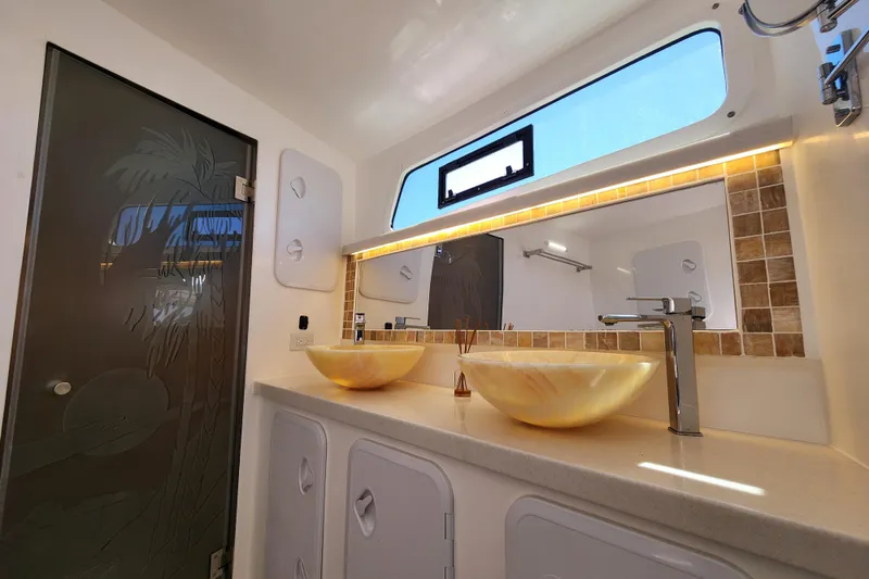 Slide: The Image of Luxurious bathroom on 2021 Royal Cape Catamarans Majestic 570 with dual sinks and elegant decor. - 78