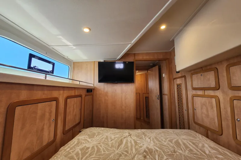 Slide: The Image of Interior cabin of 2021 Royal Cape Catamarans Majestic 570, featuring wood paneling and a mounted TV. - 81
