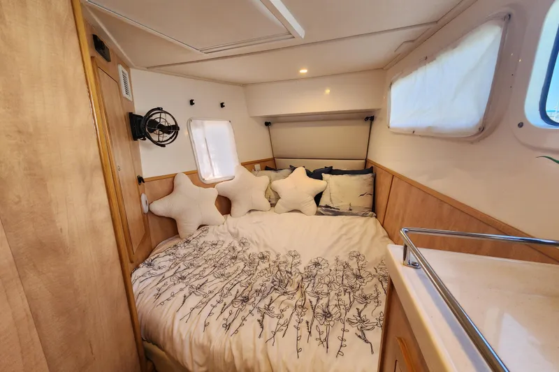 Slide: The Image of Cozy bedroom in 2021 Royal Cape Catamarans Majestic 570 with star-shaped pillows and floral bedding. - 82