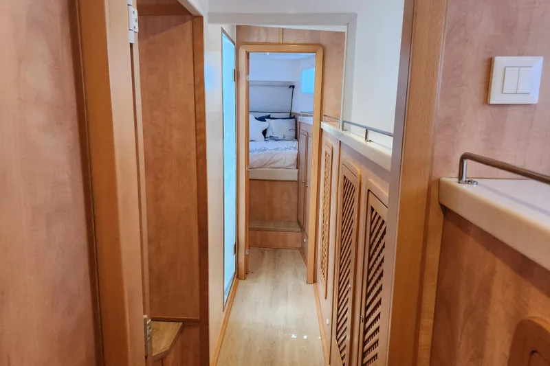 Slide: The Image of Interior hallway of 2021 Royal Cape Catamarans Majestic 570, featuring wood finishes and bedroom view. - 84