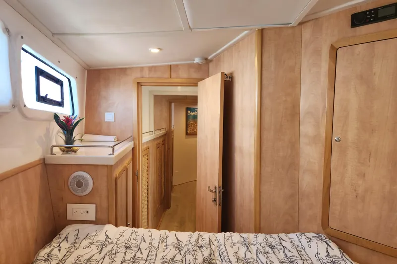 Slide: The Image of Interior of 2021 Royal Cape Catamarans Majestic 570, featuring cozy wood paneling and a small window. - 92