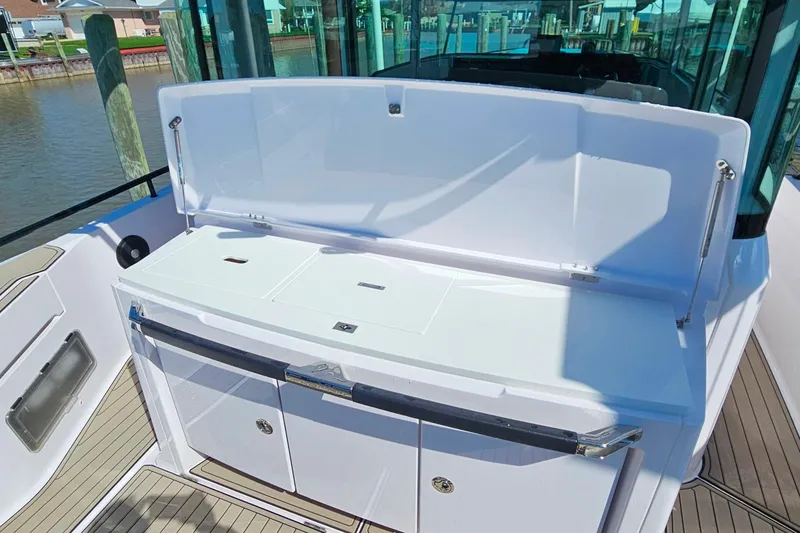 Slide: The Image of 2023 Axopar 37 XC Cross Cabin boat with sleek white deck and storage compartments. - 13
