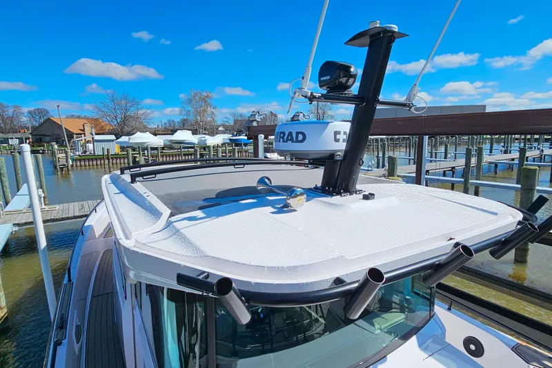 Slide: The Image of 2023 Axopar 37 XC Cross Cabin boat docked under clear blue sky. - 16