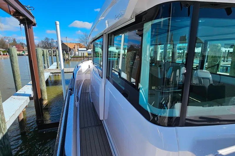 Slide: The Image of 2023 Axopar 37 XC Cross Cabin docked at a marina under a clear blue sky. - 19