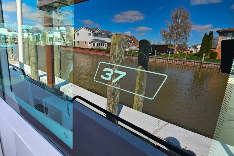 Slide: The Image of 2023 Axopar 37 XC Cross Cabin docked by a serene waterfront. - 21
