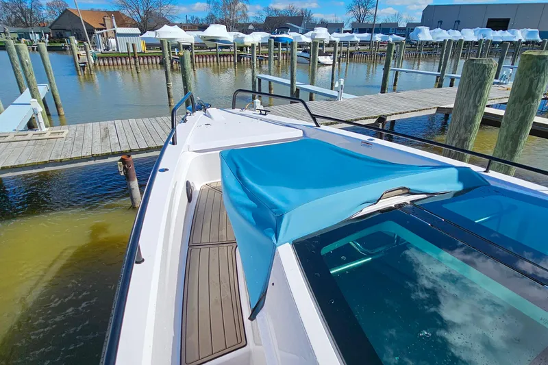 Slide: The Image of 2023 Axopar 37 XC Cross Cabin docked at marina with blue cover. - 23