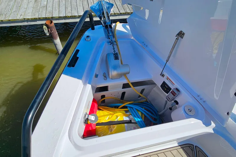 Slide: The Image of 2023 Axopar 37 XC Cross Cabin storage compartment with equipment and cables. - 26