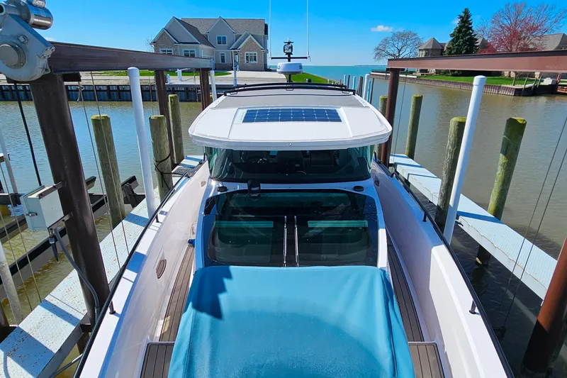 Slide: The Image of 2023 Axopar 37 XC Cross Cabin docked at a marina with waterfront homes. - 28