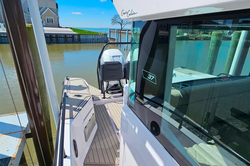 Slide: The Image of 2023 Axopar 37 XC Cross Cabin boat docked at marina under blue sky. - 3