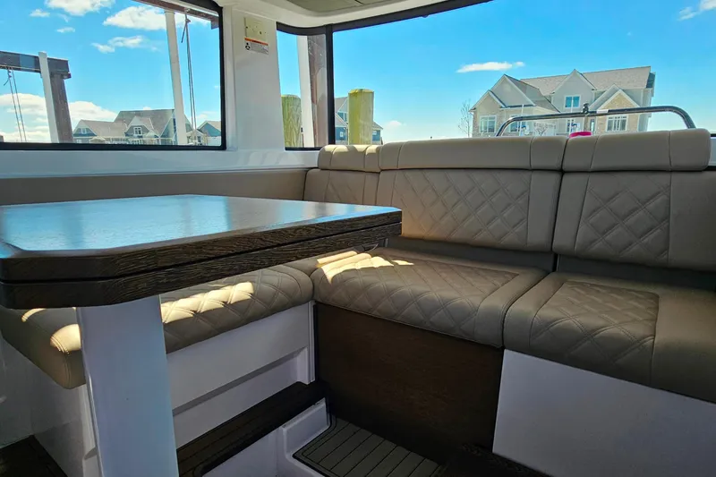 Slide: The Image of Luxurious interior of 2023 Axopar 37 XC Cross Cabin with plush seating and wooden table. - 33