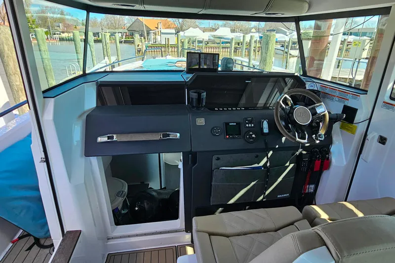 Slide: The Image of Interior view of 2023 Axopar 37 XC Cross Cabin boat cockpit with steering wheel. - 35