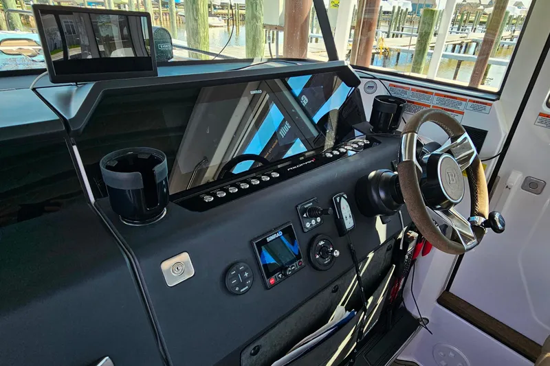 Slide: The Image of Helm of 2023 Axopar 37 XC Cross Cabin with modern controls and steering wheel. - 36