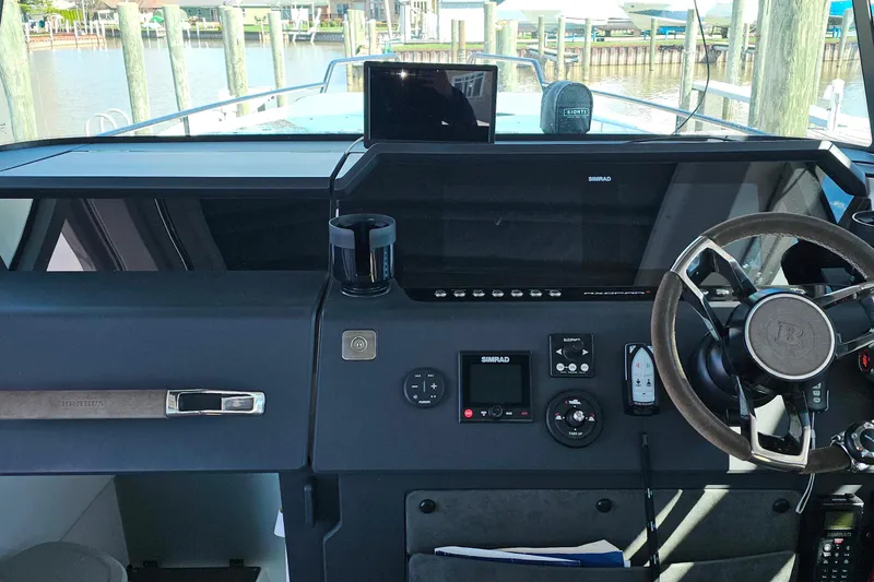 Slide: The Image of Helm of 2023 Axopar 37 XC Cross Cabin with modern navigation equipment and steering wheel. - 37