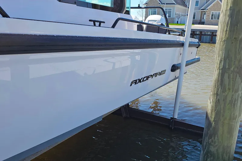 Slide: The Image of 2023 Axopar 37 XC Cross Cabin boat docked by waterfront homes. - 4