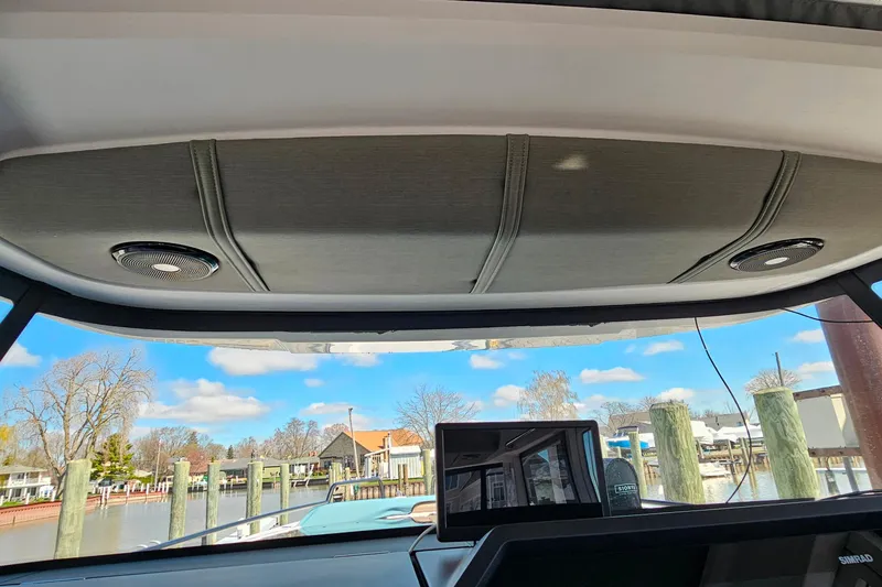 Slide: The Image of Interior view from 2023 Axopar 37 XC Cross Cabin, showcasing dashboard and scenic marina. - 41