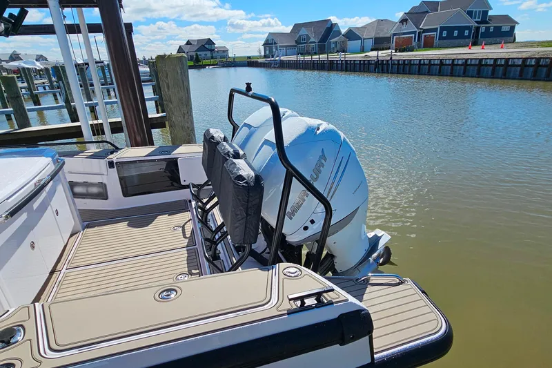 Slide: The Image of 2023 Axopar 37 XC Cross Cabin with Mercury engines docked by waterfront homes. - 5