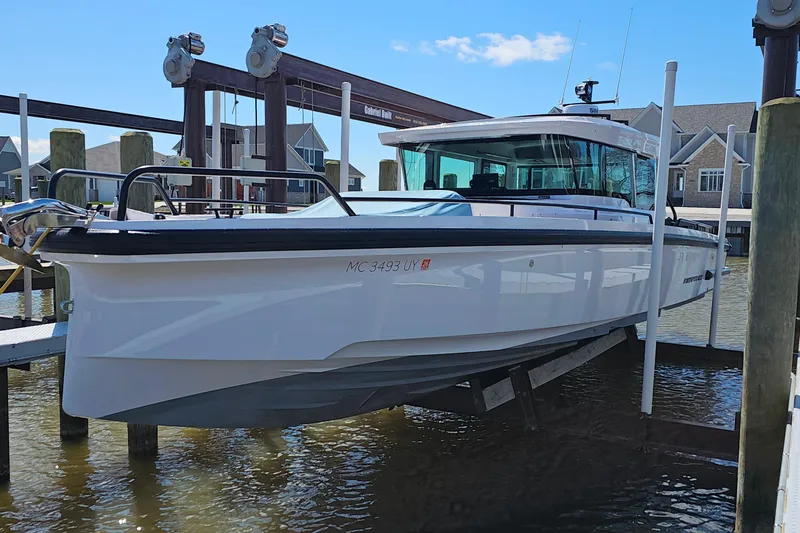 Slide: The Image of 2023 Axopar 37 XC Cross Cabin boat docked at a marina. - 53