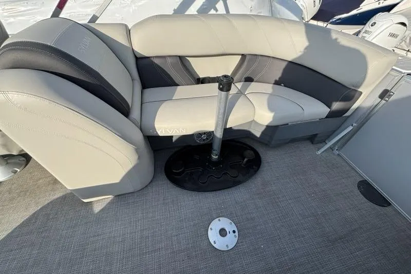 Slide: The Image of 2023 Sylvan Mirage 8522 LZ boat interior with beige seating and carpeted floor. - 13