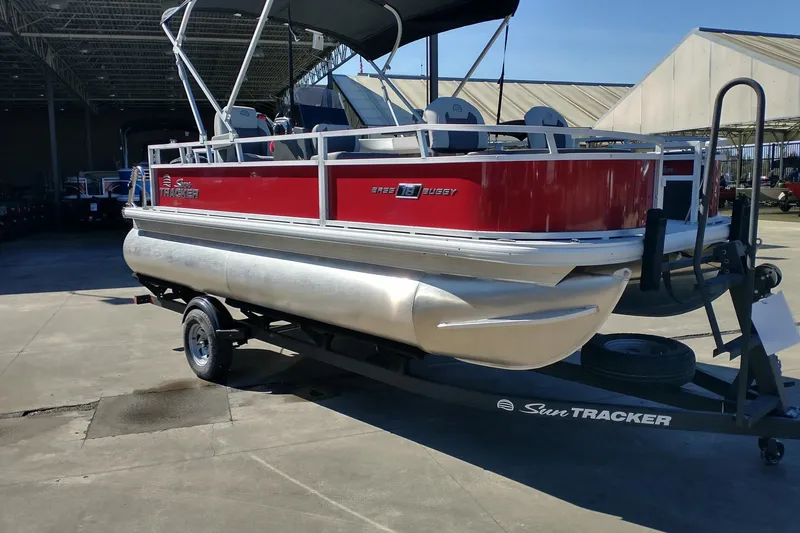 Slide: The Image of 2026 Sun Tracker Bass Buggy 18 DLX pontoon boat on trailer, red and silver design. - 2