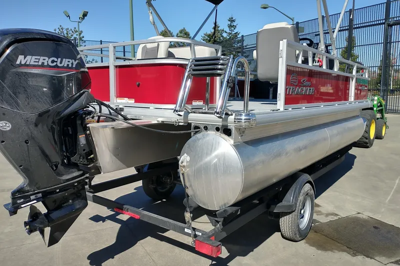 Slide: The Image of 2026 Sun Tracker Bass Buggy 18 DLX pontoon boat with Mercury outboard motor on trailer. - 4