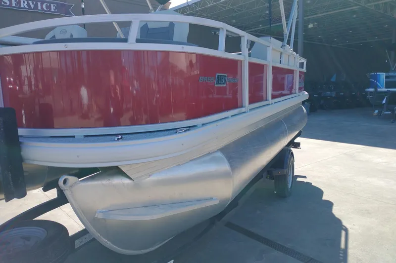 Slide: The Image of 2026 Sun Tracker Bass Buggy 18 DLX pontoon boat in a service area. - 5