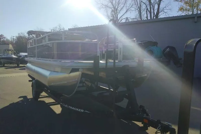 The Image of 2026 Sun Tracker Bass Buggy 16 XL Select pontoon boat on trailer in sunlight. - 0