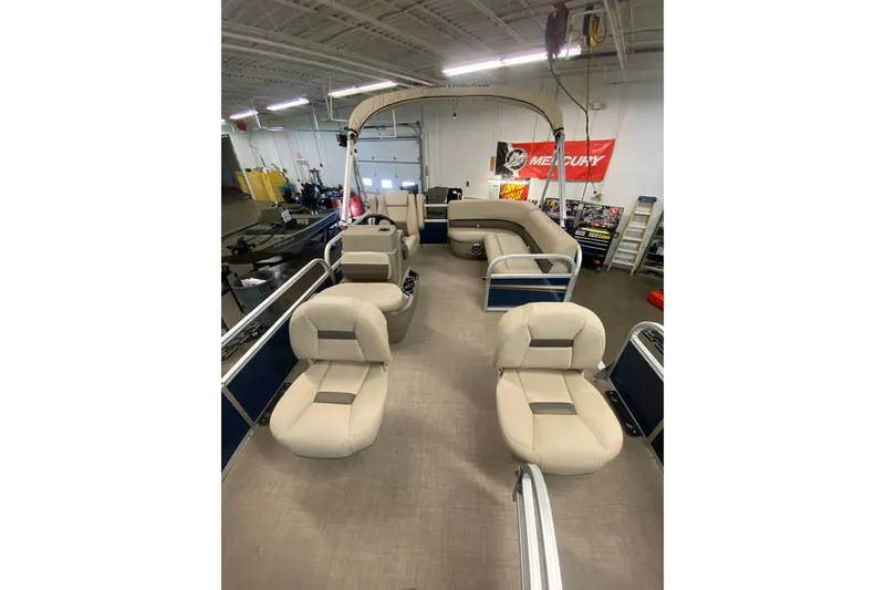 Slide: The Image of 2026 Sun Tracker Bass Buggy 16 XL Select pontoon boat with spacious seating in a showroom. - 6