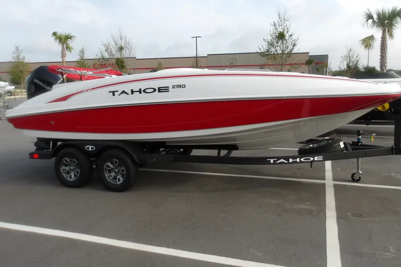 Slide: The Image of 2026 Tahoe 2150 boat in red and white on a trailer in a parking lot. - 5