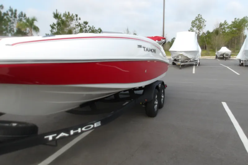 Slide: The Image of 2026 Tahoe 2150 boat with red and white design on a trailer in a parking lot. - 3