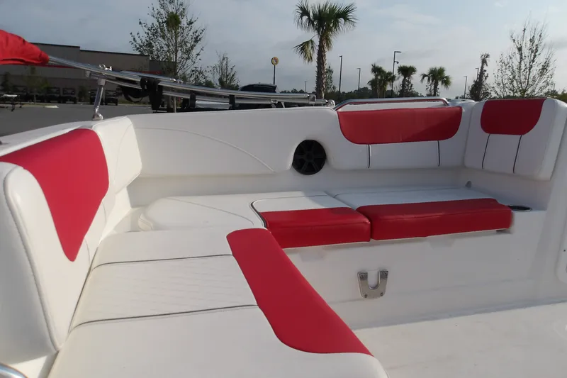 Slide: The Image of Interior of 2026 Tahoe 2150 boat with red and white seating, palm trees in background. - 14