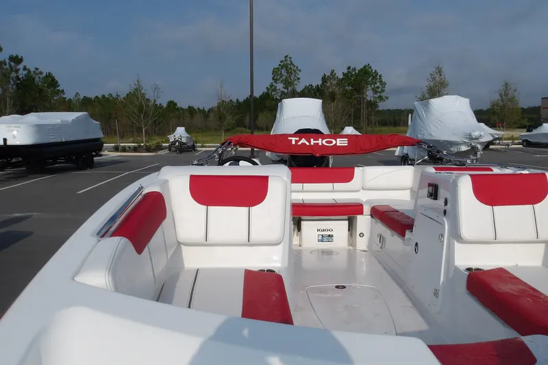 Slide: The Image of 2026 Tahoe 2150 boat with red and white seating, parked outdoors. - 10