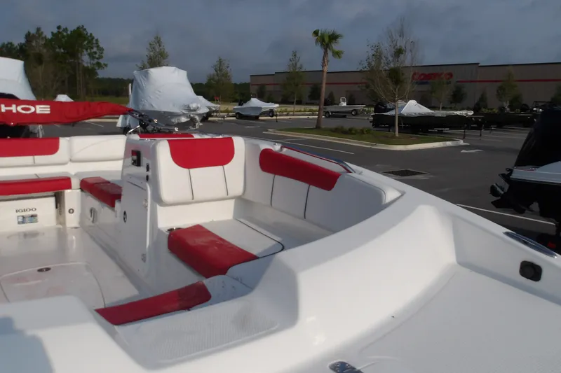 Slide: The Image of 2026 Tahoe 2150 boat with red and white seating in a parking lot. - 12