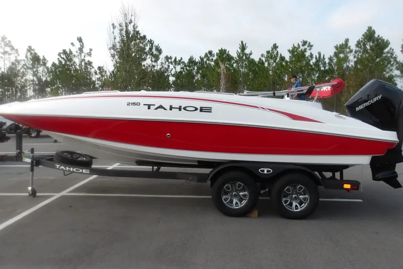 Slide: The Image of 2026 Tahoe 2150 boat with red and white design on a trailer in a parking lot. - 2