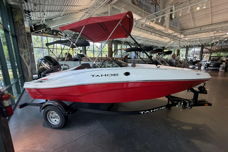 The Image of 2026 Tahoe T16 boat with red hull and canopy on display in showroom. - 0