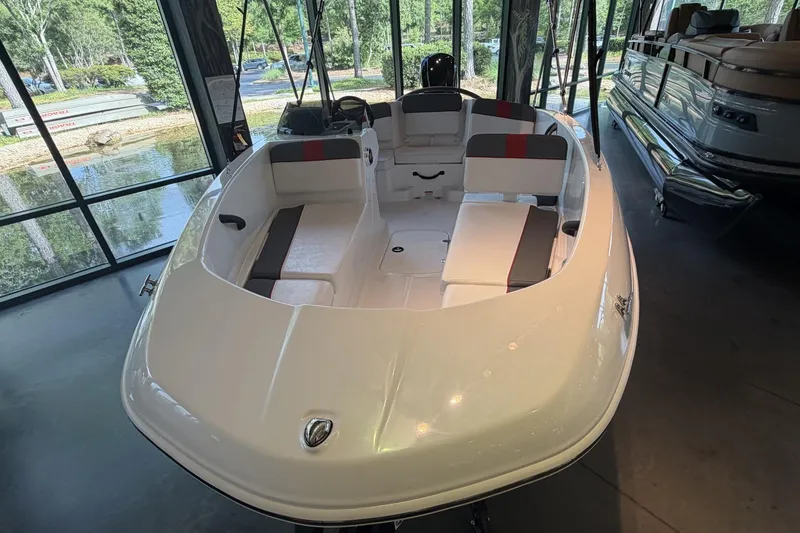 Slide: The Image of 2026 Tahoe T16 boat with sleek white design and spacious seating, displayed indoors. - 2