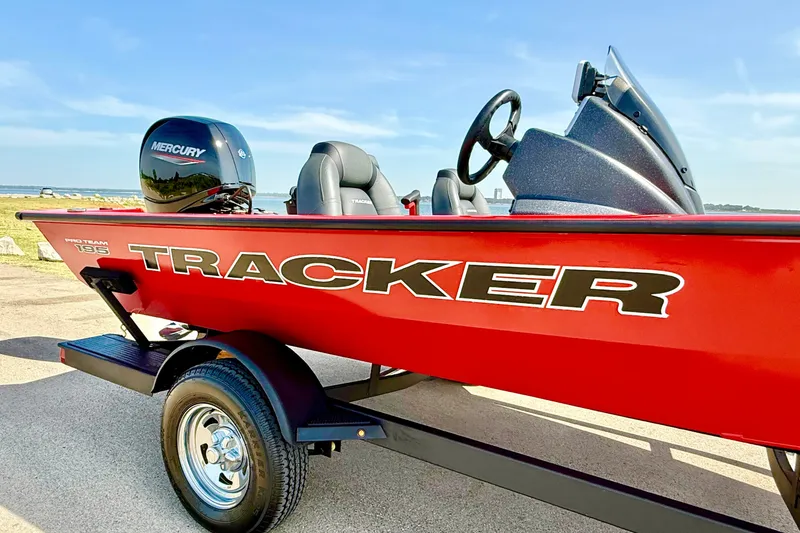 Slide: The Image of 2026 Tracker Pro Team 195 boat with Mercury engine, red exterior, parked near water. - 63