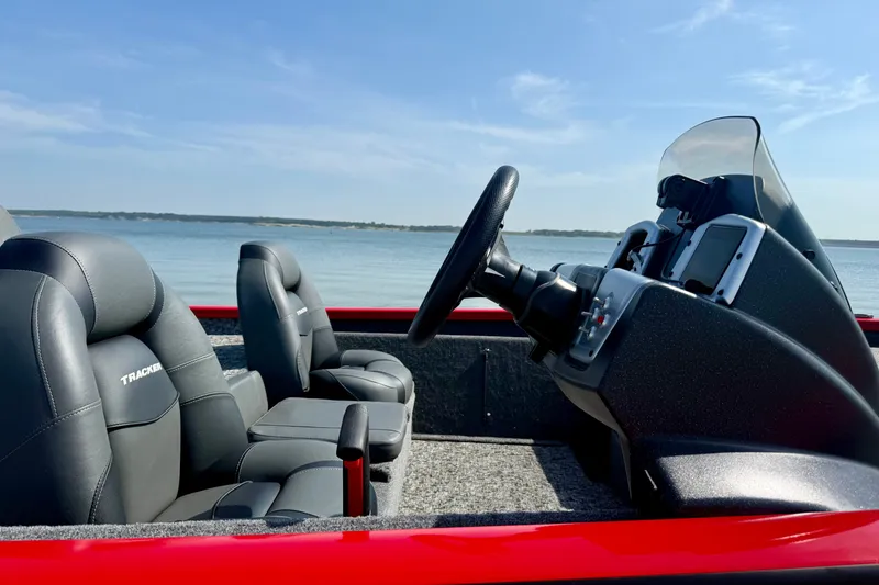 Slide: The Image of 2026 Tracker Pro Team 195 boat interior with steering wheel and seats by the water. - 55