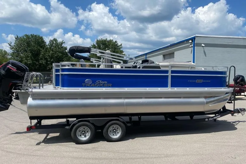 Slide: The Image of 2026 Sun Tracker Fishin' Barge 20 DLX pontoon boat on trailer, parked outdoors. - 5